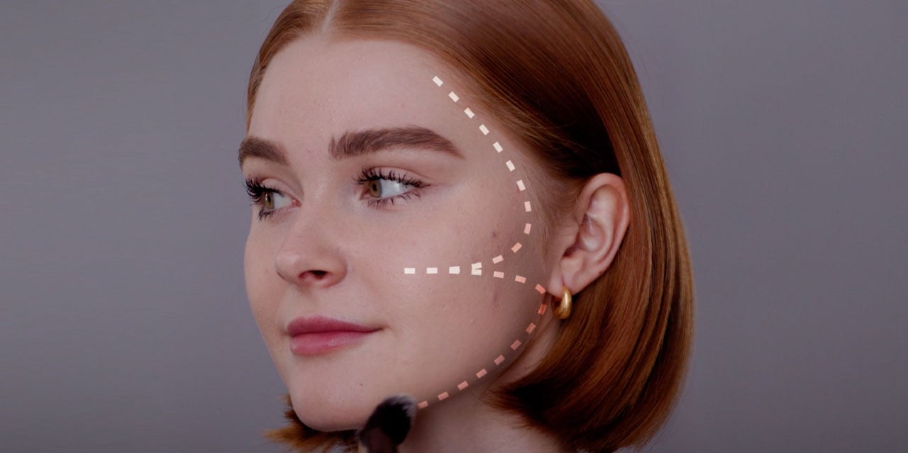 Makeup artist applying bronzer to model using the 3 technique for a sun-kissed look